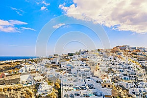 Aerial drone view of famous Oia village with white houses and blue dome churches on Santorini island, Aegean sea, Greece