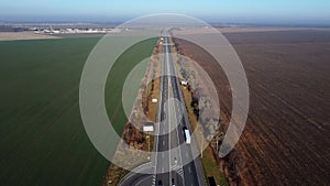 Aerial Drone View Flight Over highway between the fields on sunny day.