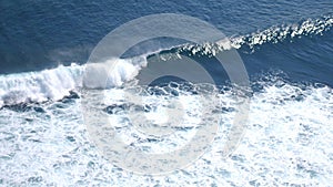 Aerial drone view of foaming waves in ocean