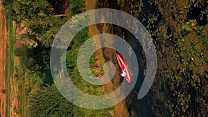 Aerial drone view following kayak paddling in river at sunset. Vertical video