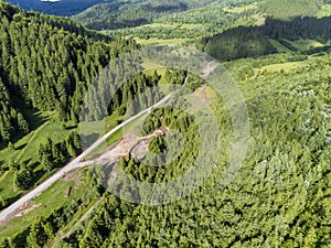 Aerial drone view, forest road near small flooded mountain river