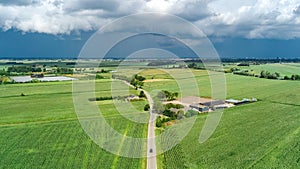 Aerial drone view of green fields and farm houses near canal, typical Dutch landscape, Holland, Netherlands