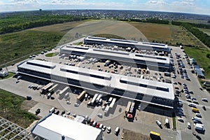 Aerial drone view of group of large modern industrial warehouse or factory buildings in suburban city area.Logistic