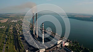 Aerial drone view of high chimney pipes with grey smoke from coal power plant. wide view V2