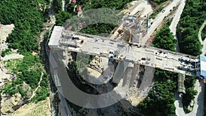 Aerial drone view on highway bridge road under construction. Construction of the viaduct on the modern new road.