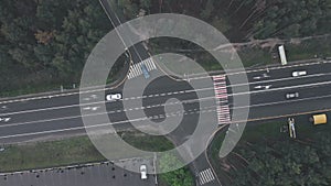 Aerial drone view of highway road with moving cars. Modern speedy highway with road markings, top view. Crossroad with moving cars