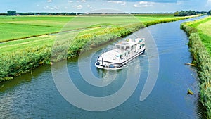 Aerial drone view of houseboat in canal and country landscape of Holland from above, family travel by barge boat in Netherlands