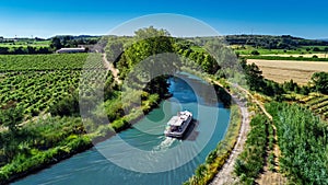 Aerial drone view of houseboat in Canal du Midi from above, family travel by boat, vacation in France