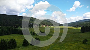 Aerial drone view of Jundola village with houses surrounded by beautiful meadows and forests