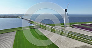 Aerial drone view of the Ketelbrug and sustainbale wind turbine along the water at the Ijselmeer in The Netherlands.