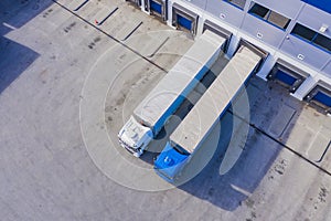 Aerial drone view on logistics center with trucks at the loading bays