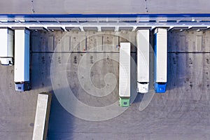 Aerial drone view on logistics center with trucks at the loading bays