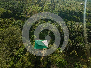 Aerial drone view of a lookout tower with green roof at a farmland in Jasin, Melaka, Malaysia