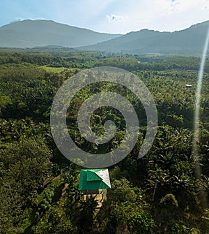 Aerial drone view of a lookout tower with green roof at a farmland in Jasin, Melaka, Malaysia