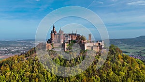 Aerial drone view of medieval Hohenzollern castle on top of hill in autumn, Baden-Wurttemberg, Germany