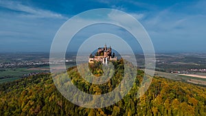 Aerial drone view of medieval Hohenzollern castle on top of hill in autumn, Baden-Wurttemberg, Germany