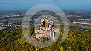 Aerial drone view of medieval Hohenzollern castle on top of hill in autumn, Baden-Wurttemberg, Germany