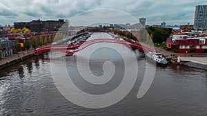 Aerial drone view of modern footbridge Python Bridge at Eastern Docklands neighborhood of Amsterdam Netherlands