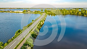 Aerial drone view of motorway road and cycling path on polder dam, cars traffic from above, Holland, Netherlands