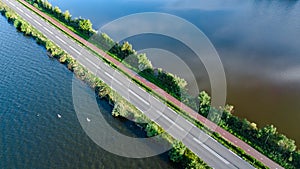 Aerial drone view of motorway road and cycling path on polder dam, cars traffic from above, Holland, Netherlands
