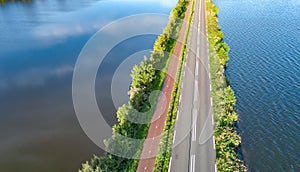 Aerial drone view of motorway road and cycling path on polder dam, cars traffic from above, Holland, Netherlands