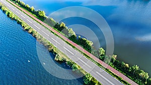 Aerial drone view of motorway road and cycling path on polder dam, cars traffic, North Holland, Netherlands