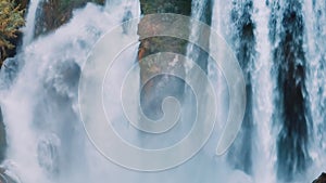 Aerial drone view of a natural waterfall close-up. Spray. Foam. Green vegetation on the rocks. Natural element.