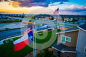 Aerial drone view next to American Flag and Texas Flag flying high above Modern day Subrub Developments