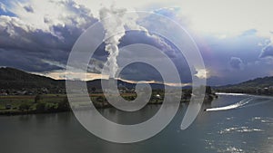 Aerial drone view of nuclear power plant and river against stormy rainy clouds