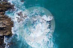Aerial view of ocean`s beautiful waves and rocky coast photo