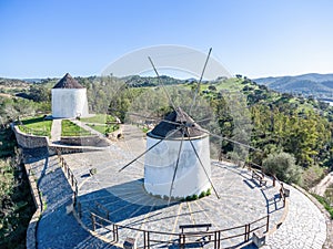 Aerial drone view of old white windmills in a hill of Sanlucar de Guadiana village in Huelva province, Andalusia,