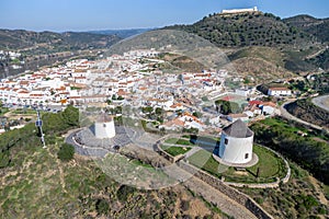 Aerial drone view of old white windmills in a hill of Sanlucar de Guadiana village in Huelva provine, Andalusia,