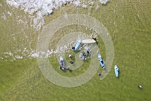 Aerial drone view of people surfing in the sea. Summer sport learning how to surf. Surfboarding in baltic sea Jastarnia, Poland