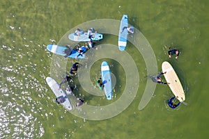 Aerial drone view of people surfing in the sea. Summer sport learning how to surf. Surfboarding in baltic sea Jastarnia, Poland