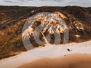 Aerial Drone view of The Pinnacles, Colored Sands on Fraser Island, Sunrise with car. Kgari, Queensland, Australia.