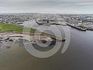 Aerial drone view on river Corrib and South park and Claddagh area and port, Galway city, Ireland. Cloudy sky. High tide