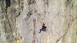 AERIAL: Drone view of a rock climber looking for a hold while learning to climb