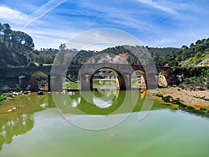 Aerial drone view of roman bridge in the hiking route of the water mills along the Odiel river from Sotiel Coronada