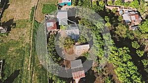 Aerial drone view of rural houses in Asia with children`s white kite seen flying above the houses.