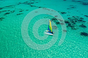 Aerial drone view of sailing sailboat surf or catamaran in turquoise water of Caribbean sea near Punta Cana beach