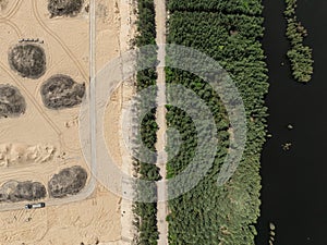 Aerial drone view of a sand mine in the forest. Loader Loading Sand Into Dump Truck In Sand Pit. Quarrying sand. Machines and photo