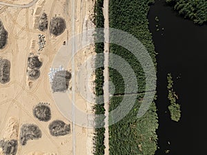 Aerial drone view of a sand mine in the forest. Loader Loading Sand Into Dump Truck In Sand Pit. Quarrying sand. Machines and photo