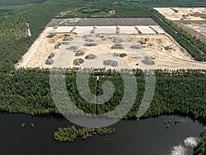 Aerial drone view of a sand mine in the forest. Loader Loading Sand Into Dump Truck In Sand Pit. Quarrying sand. Machines and photo