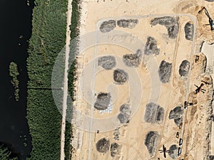 Aerial drone view of a sand mine in the forest. Loader Loading Sand Into Dump Truck In Sand Pit. Quarrying sand. Machines and photo