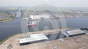 Aerial drone view of a sea platform with a crane on top sailing through the Amsterdam Westpoort, The Netherlands.