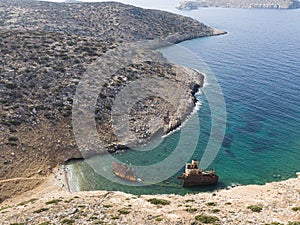 Aerial drone view of Shipwreck Olympia boat in Amorgos island during summer holidays, at the coastal rocky area, people on the