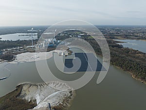 Aerial drone view on solar panels on water. Quarry and sand extraction. Sustainable innovations.