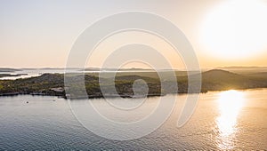 Aerial drone view of sunset over Kornati islands near the Sibenik city, Croatia. Water bay with boats ans soft sun light