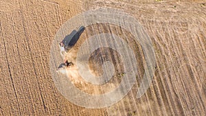 Aerial drone view of a tractor tilling the land