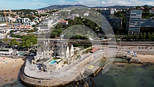 Aerial drone view of train approaching Cascais train station close to the sea promenade